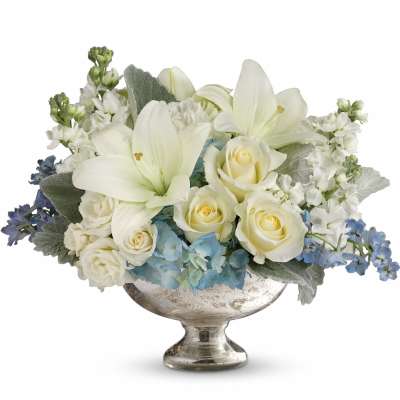 White roses and lilies in a silver pedestal vase with blue accents