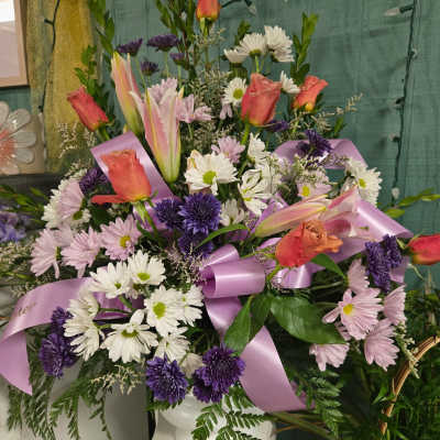 Mixed bouquet with pink roses, lilies, and purple daisies tied with lavender ribbon