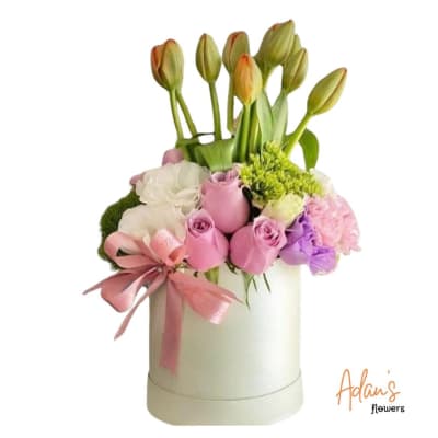 Pink and white floral arrangement in a white hatbox with a ribbon bow