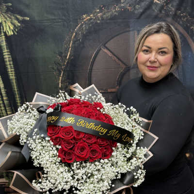Large bouquet of red roses with white baby's breath and a birthday ribbon