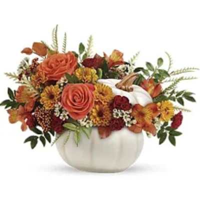 Orange roses and autumn flowers arranged in a white pumpkin vase