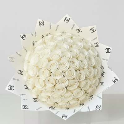 Bouquet of white roses wrapped in Chanel-logo paper
