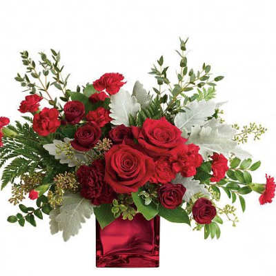 Red roses and carnations in a red glass vase with silver foliage