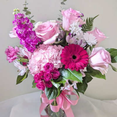 Pink and magenta mixed bouquet in a glass vase with a ribbon