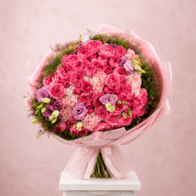Pink bouquet of roses and lisianthus wrapped in pale pink paper