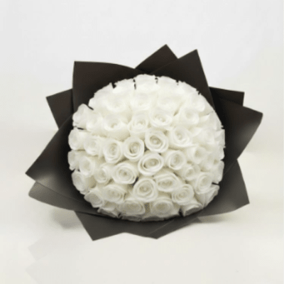 Round bouquet of white roses wrapped in black paper