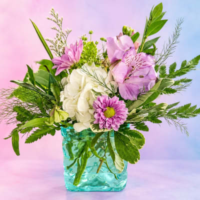 Pink and white flowers arranged in a turquoise glass vase