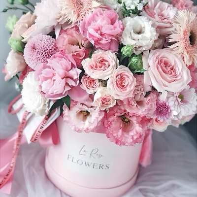 Pink and white bouquet in a round hatbox with ribbon