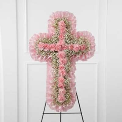Pink floral cross-shaped standing spray on an easel