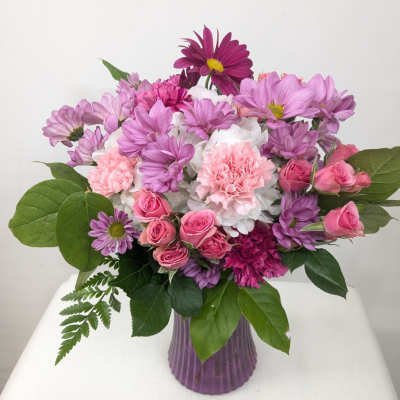 Pink and purple mixed bouquet in a ribbed purple vase