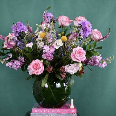 Pink and purple mixed bouquet in a dark glass vase