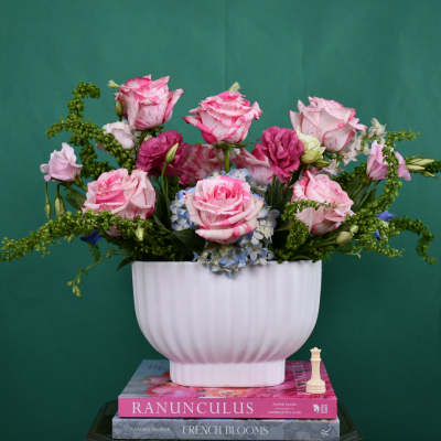 Pink roses and blue hydrangeas in a white vase