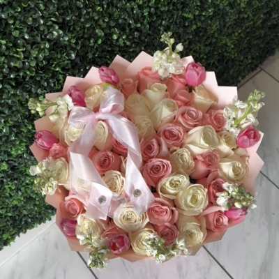 Bouquet of pink and cream roses with tulips and a satin ribbon