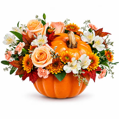 Pumpkin centerpiece with peach roses, white alstroemeria, and orange mums
