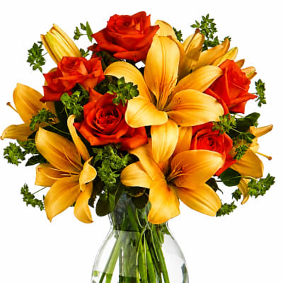 Orange roses and yellow lilies in a clear glass vase