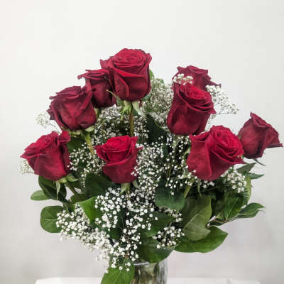 Red roses in a clear glass vase with white baby's breath