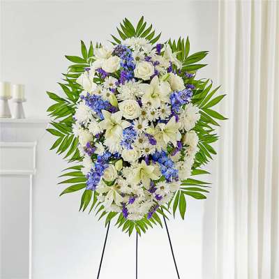 Standing floral spray of white and blue flowers on an easel