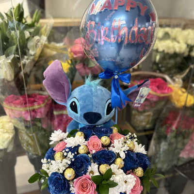 Blue Stitch plush with a birthday balloon and flower box arrangement