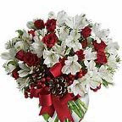 Red roses and white flowers in a glass vase with a red ribbon