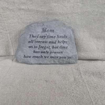Gray memorial stone engraved with a Mom remembrance verse on a neutral fabric background.