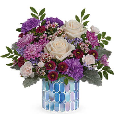 Bouquet of cream roses, purple mums, and pink flowers in a blue mosaic vase