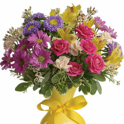 Bouquet of pink, purple, and yellow flowers in a yellow vase with a ribbon