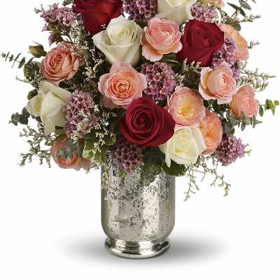 Bouquet of red, white, and peach roses in a silver vase