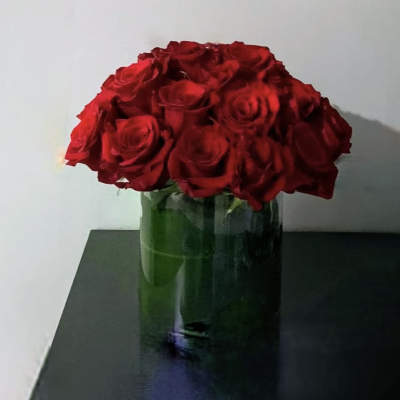 Red roses arranged in a clear glass vase