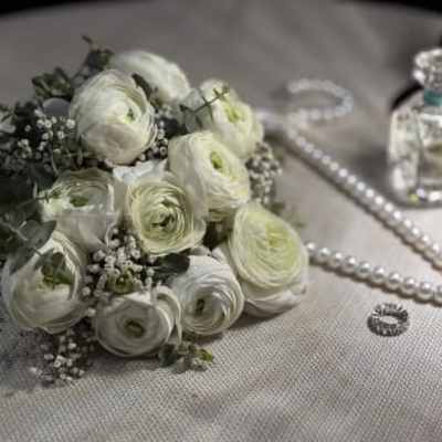 White ranunculus bouquet with baby's breath and dark greenery