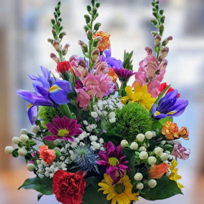 Colorful mixed bouquet in a black container with tall blooms