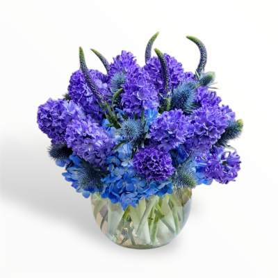 Blue and purple flower arrangement in a clear glass vase