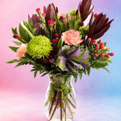 Mixed bouquet in a clear glass vase with pink, green, and burgundy flowers