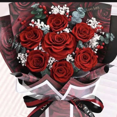 Bouquet of red roses with white filler flowers and dark wrapping