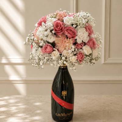 Pink and white rose bouquet arranged in a champagne bottle vase