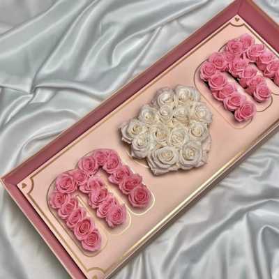 Pink and white roses arranged in a decorative gift box