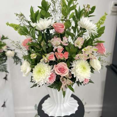 Pink and white flower arrangement in a white vase