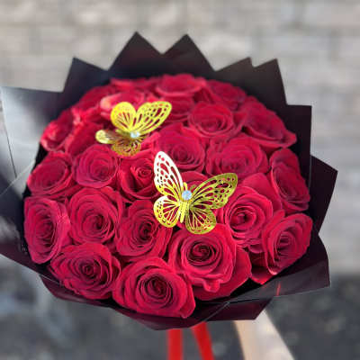 Bouquet of red roses with yellow butterfly decorations in black wrap