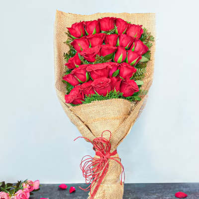 Bouquet of red roses wrapped in burlap with a red tie