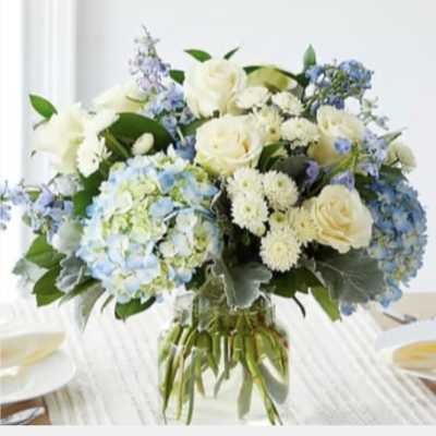 White roses and blue hydrangeas in a glass vase