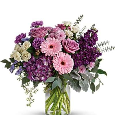 Purple and pink mixed bouquet in a clear glass vase