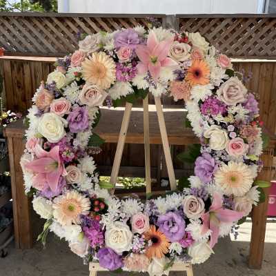 Large floral wreath with pink, white, and lavender blooms on an easel