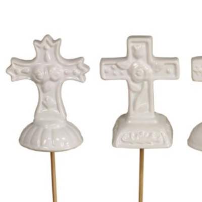 Set of three small white cross ornaments on picks with different embossed designs.