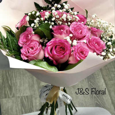Bouquet of pink roses with baby's breath wrapped in pale paper