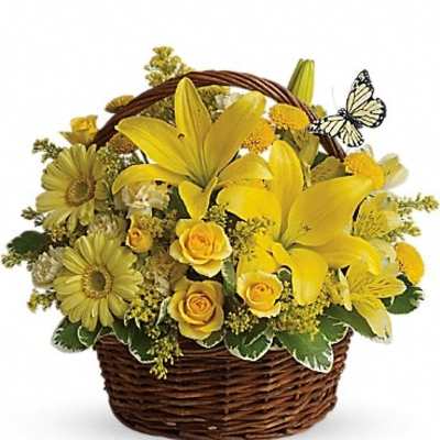 Yellow flower arrangement in a wicker basket with a butterfly accent