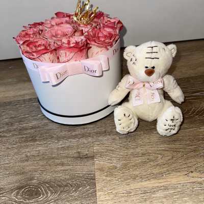 Beautiful duo (Dior): a box with two-tone roses, a metallic crown, a pink Dior ribbon and bow, and a Dior teddy bear with a bow.
