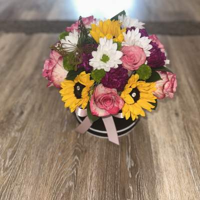Mixed bouquet in a black round box with pink, yellow, white, and purple flowers