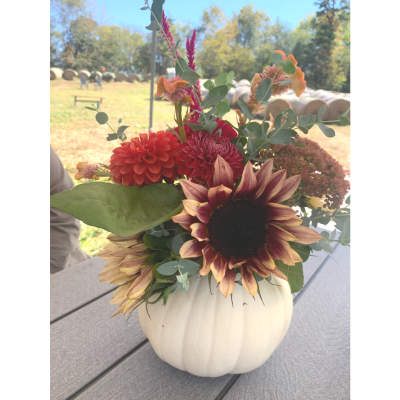Fall bouquet in a white pumpkin vase with sunflowers and dahlias