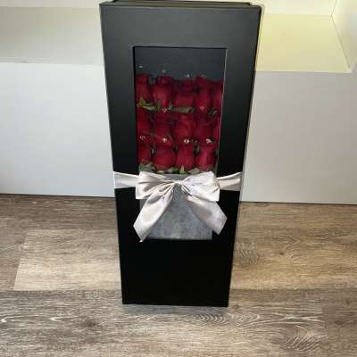 Black gift box with red roses and a silver ribbon bow
