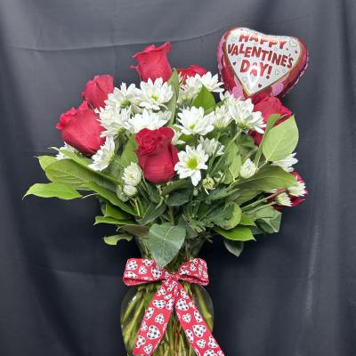 Red roses and white daisies in a glass vase with a Valentine heart balloon