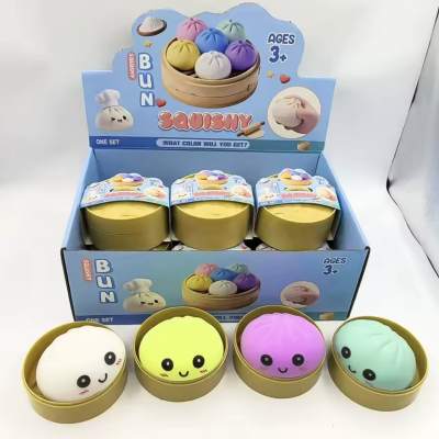 Four colorful squishy toys in round tins with a display box behind them